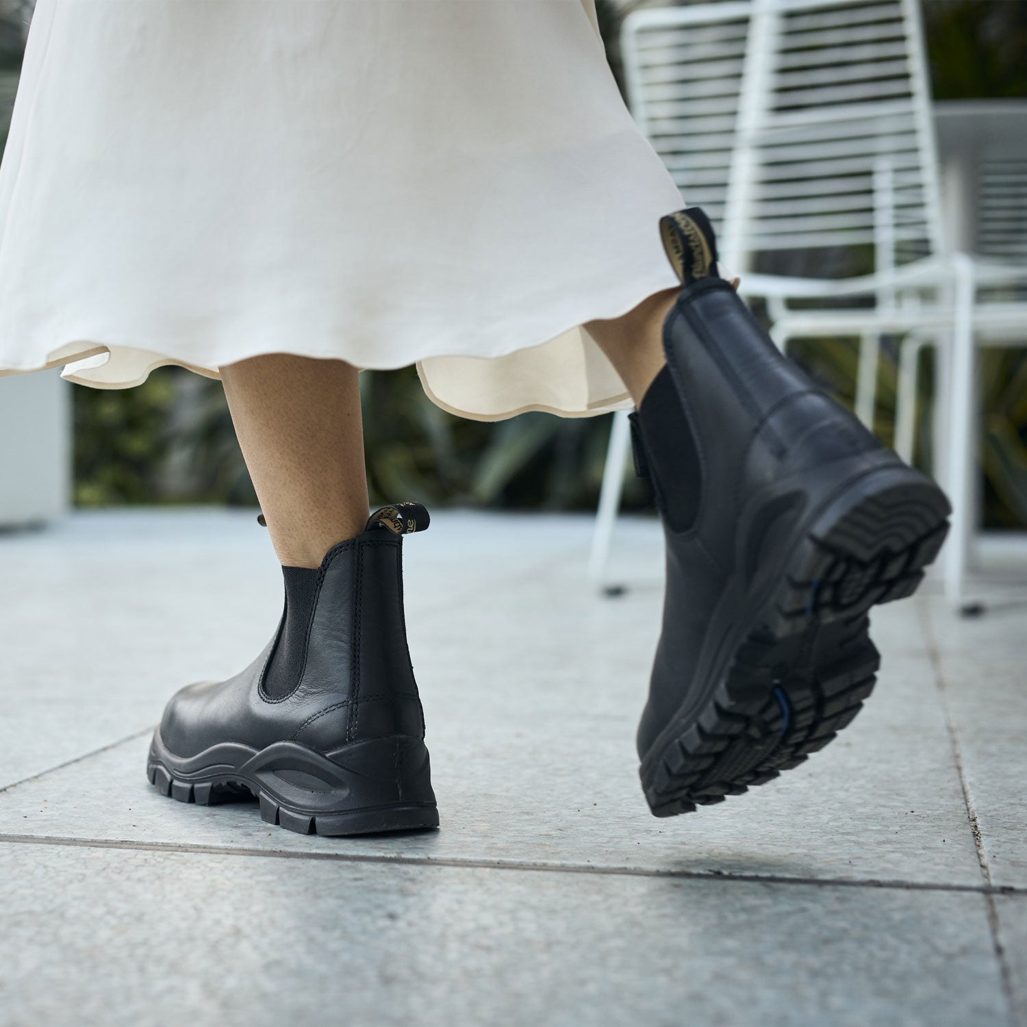 Blundstone 2240 Lug Sole Black walking wearing a white dress.