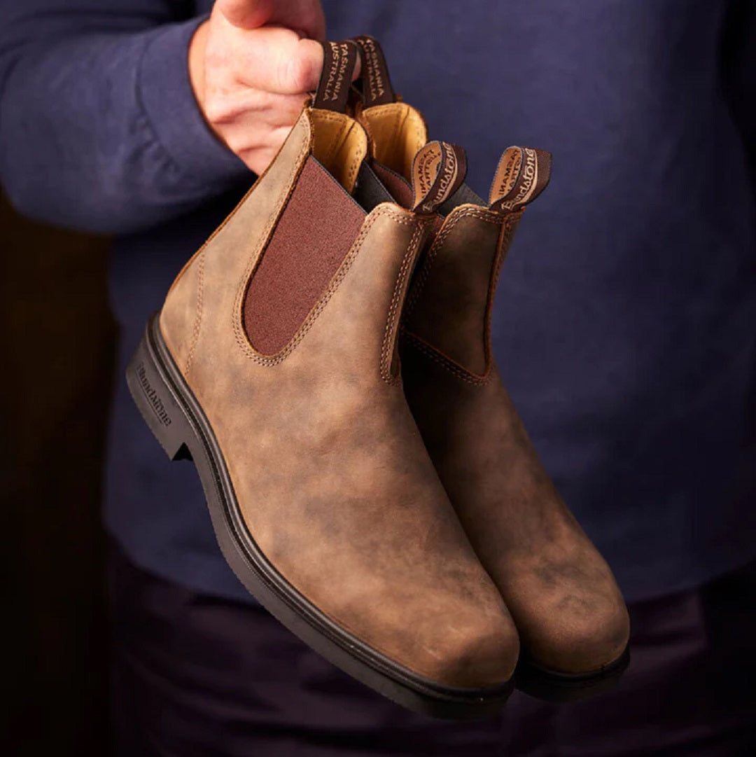 Blundstone boots being held by model by pull tabs