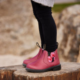 Blundstone 2251 Kids Mauve with Pink Rose Elastic standing on a log.